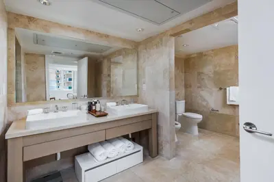 a bathroom with two sinks and a toilet and a mirror at Oceanview Private Condo at 1 Hotel & Homes -1040 in Miami Beach