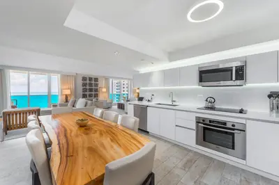 a kitchen and dining room with a wooden table at Oceanview Private Condo at 1 Hotel & Homes -1040 in Miami Beach