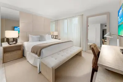 a bedroom with a large bed and a desk at Oceanview Private Condo at 1 Hotel & Homes -1211 in Miami Beach