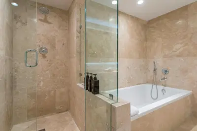 a bathroom with a shower with a tub and a shower stall at Oceanview Private Condo at 1 Hotel & Homes -1015 in Miami Beach
