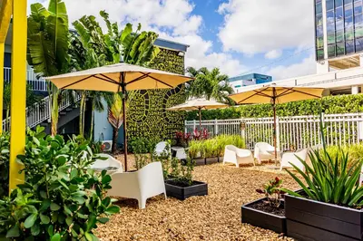 a patio with chairs and umbrellas and plants at Up Midtown in Miami