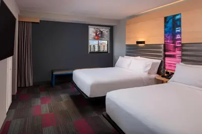 two beds in a hotel room with two bedsskirtspectspectssenalsenal at Aloft Coral Gables in Miami