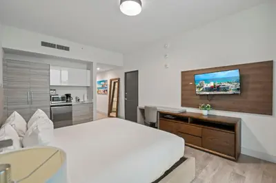 a bedroom with a bed and a desk and a television at CH Luxury Condos & Studios On The Beach in Hollywood