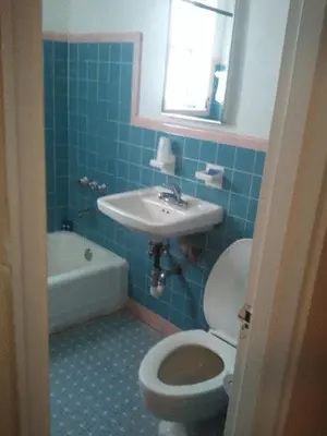a blue bathroom with a toilet and a sink at Collins Avenue Hostel in Miami Beach