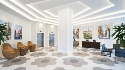 a lobby with chairs and paintings on the walls at Hyatt Centric Brickell Miami in Miami
