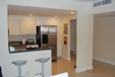 a kitchen with a stainless steel refrigerator and stools at Ocean Reserve Piso 7 STR-310 in Miami Beach
