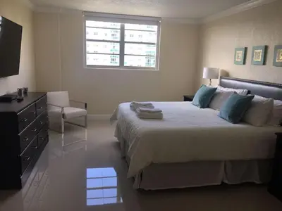 a bedroom with a bed and a dresser and a window at Ocean Reserve Piso 4 STR264 in Miami Beach