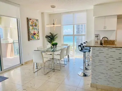 a kitchen and dining room with a table and chairs at The King David Condos in Miami Beach