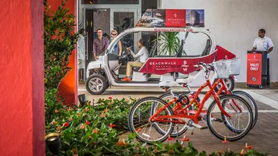 a bike parked in front of a golf cart at Three-Bedroom Beachwalk Resort Apartment in Hallandale Beach