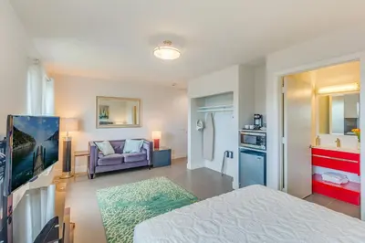 a bedroom with a bed and a couch and a kitchen at Costa Norte Boutique Hotel Miami Beach in Miami Beach