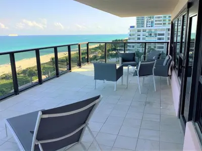a balcony with chairs and a view of the ocean at Luxury Beach Resort - HORA RENTALS in Miami Beach