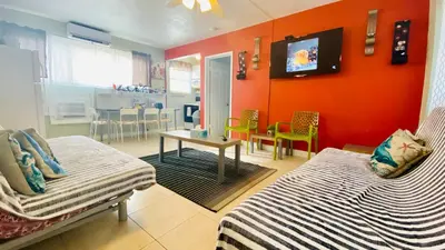 a room with two beds and a table with a tv at Hollywood Beachfront House in Hollywood