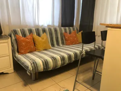 a couch with colorful pillows on it in a living room at Hollywood Beachfront House in Hollywood