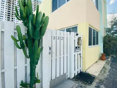 a cactus in front of a fence next to a building at Hollywood Beachfront House in Hollywood