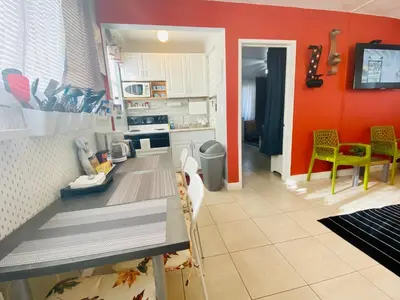 a kitchen with red walls and a table in a room at Hollywood Beachfront House in Hollywood