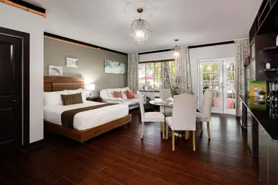 a bedroom with a bed and a table and chairs at Tradewinds Apartment Hotel Miami Beach in Miami Beach
