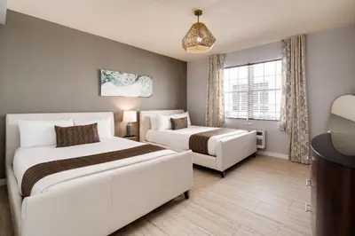 a hotel room with two beds and a window at Tradewinds Apartment Hotel Miami Beach in Miami Beach