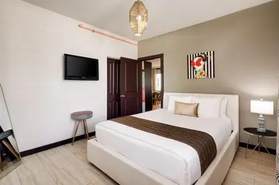 a hotel room with a bed and a tv at Tradewinds Apartment Hotel Miami Beach in Miami Beach