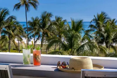 a table with a hat and glasses on a balcony with the beach at Marriott Vacation Club, South Beach in Miami Beach