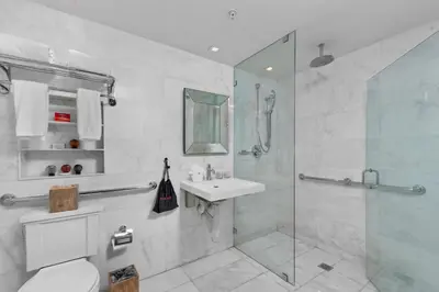 a bathroom with a shower and a toilet and a sink at Bentley Hotel South Beach in Miami Beach