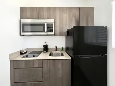 a kitchen with a black refrigerator and a microwave at Beach Gardens in Fort Lauderdale