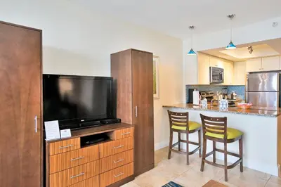 a kitchen with a flat screen tv and a bar at Hollywood Beach Tower in Hollywood