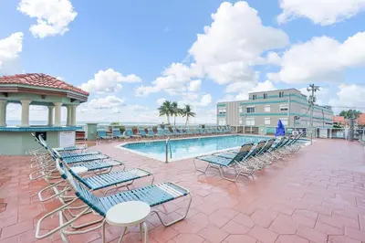 a pool with chaise lounge chairs and a table and a building at Hollywood Beach Tower in Hollywood