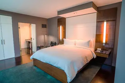 a bedroom with a large white bed and a desk at Hotel Beaux Arts, Autograph Collection in Miami