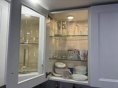 a cabinet filled with plates and cups and glasses at King condo Fort Lauderdale Central beach in Fort Lauderdale