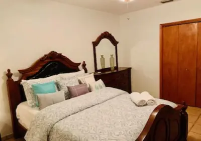 a bedroom with a large bed with a large mirror at Blue House Miami in Miami Beach