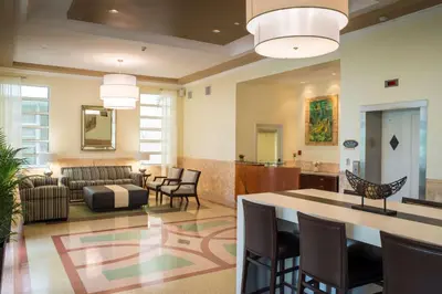 a living room with a couch and a table and chairs at Hilton Grand Vacations Club Mcalpin Ocean Plaza Miami in Miami Beach