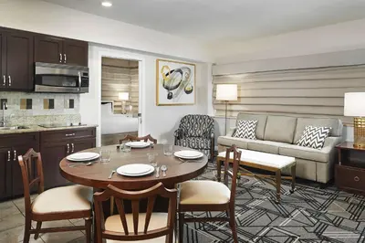 a kitchen and a living room with a table and chairs at Hilton Grand Vacations Club Mcalpin Ocean Plaza Miami in Miami Beach