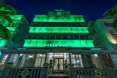 a building lit up green at night at Hilton Grand Vacations Club Mcalpin Ocean Plaza Miami in Miami Beach