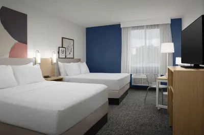 a hotel room with two beds and a flat screen tv at Spark by Hilton Miami Doral in Miami