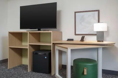a room with a desk with a television and a trash can at Spark by Hilton Miami Doral in Miami