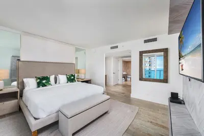a bedroom with a large bed and a living room at Oceanview Private Condo at 1 Hotel & Homes -1122 in Miami Beach