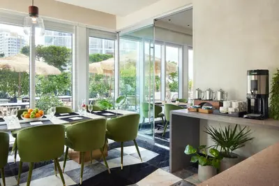 a dining room with a table and chairs and windows at W Miami in Miami
