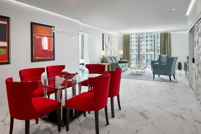 a dining room with red chairs and a glass table at W Miami in Miami