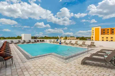 a swimming pool on the roof of a building with lounge chairs at Wyndham Garden Ft Lauderdale Airport & Cruise Port in Dania Beach