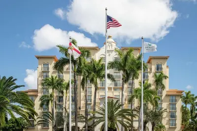 a hotel with palm trees in front of it at Embassy Suites by Hilton Miami International Airport in Miami