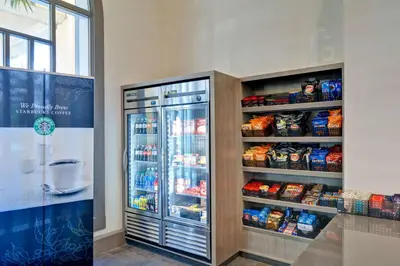 a refrigerator filled with lots of food next to a window at Embassy Suites by Hilton Miami International Airport in Miami