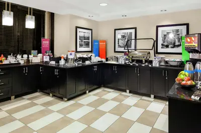 a kitchen with black cabinets and a checkered floor at Hampton Inn Miami/Dadeland in South Miami