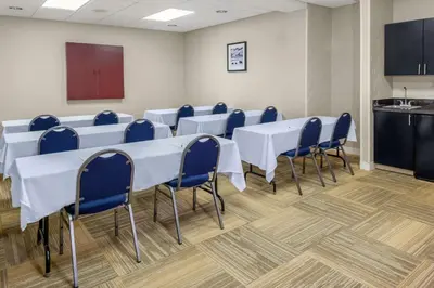 a conference room with white tables and blue chairs at Hampton Inn Miami/Dadeland in South Miami