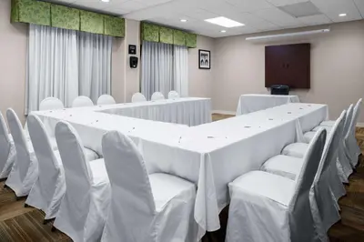 a conference room with a long table and white chairs at Hampton Inn Miami/Dadeland in South Miami