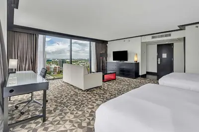 a hotel room with a bed and a desk and a television at Hilton Miami Downtown in Miami