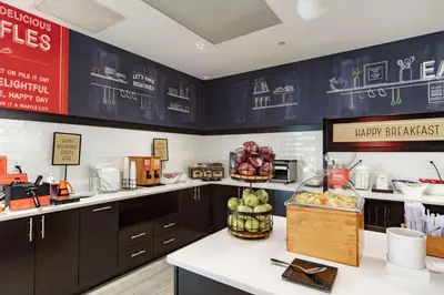 a kitchen with a counter with fruits and vegetables on it at Hampton Inn & Suites Miami Airport South/Blue Lagoon in Miami
