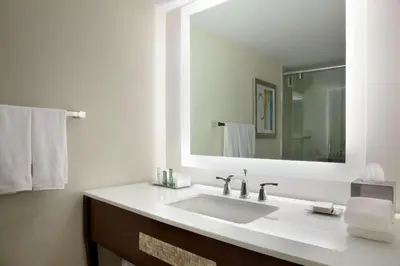 a bathroom with a white sink and a mirror at Hilton Miami Airport Blue Lagoon in Miami
