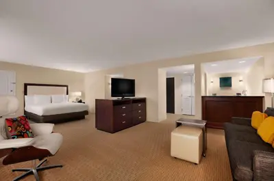 a hotel room with a bed and a living room at Hilton Miami Airport Blue Lagoon in Miami