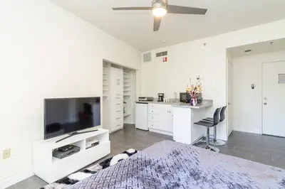 a bedroom with a bed with a television and a desk at Ocean Drive Studio Historic Building minutes walk to the Beach. in Miami Beach