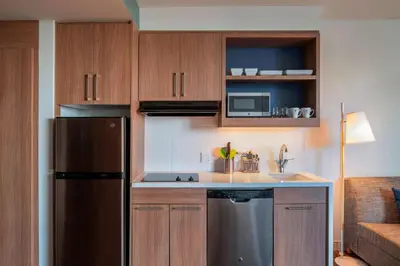 a kitchen with wooden cabinets and a stainless steel refrigerator at Element Fort Lauderdale Downtown in Fort Lauderdale